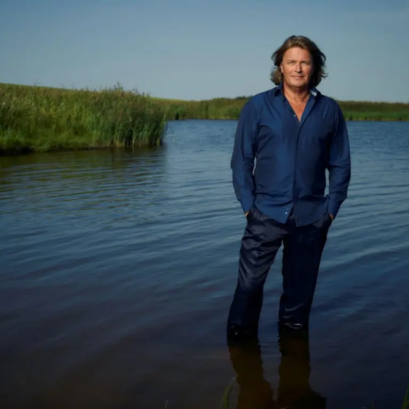 Ein Mann steht im Wasser einer ruhigen Landschaft unter blauem Himmel. | © Wolfgang Wilde