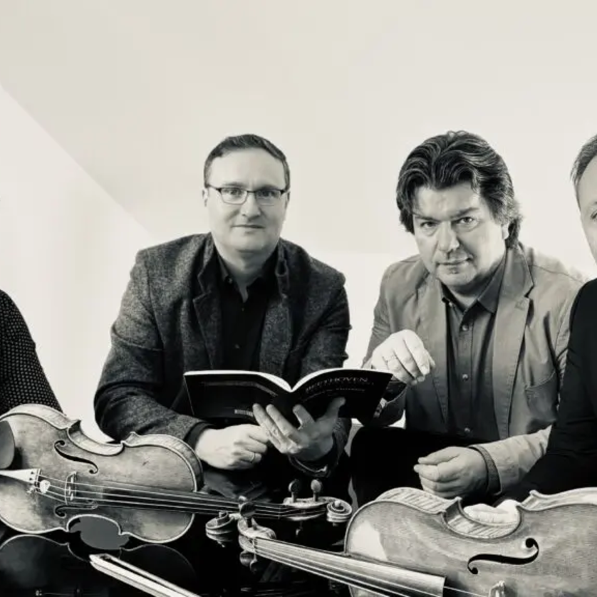 Vier Musiker mit Instrumenten studieren ein Notenbuch. | © Jerusalem Quartet