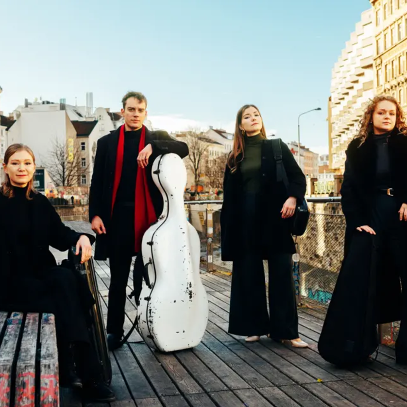 Vier Musiker posieren stilvoll vor urbaner Kulisse. | © Andreas Jakwerth