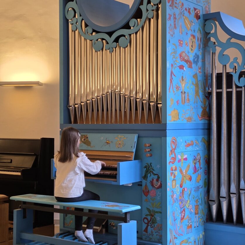 Ein Mädchen spielt an einer farbenfrohen, dekorierten Orgel. | © Maria Krajewska