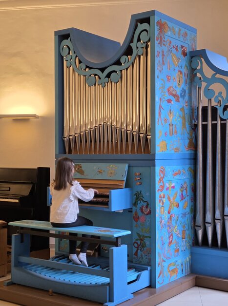 Ein Mädchen spielt an einer farbenfrohen, dekorierten Orgel. | © Maria Krajewska