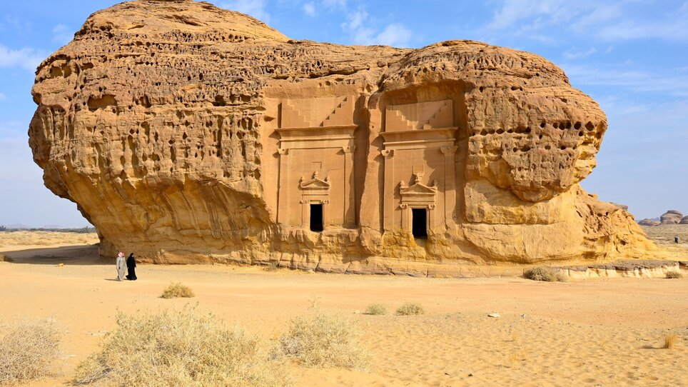 Ein Felsengrab mit zwei Eingängen vor einer Wüstenlandschaft in Saudi Arabien. | © Gerhard Huber
