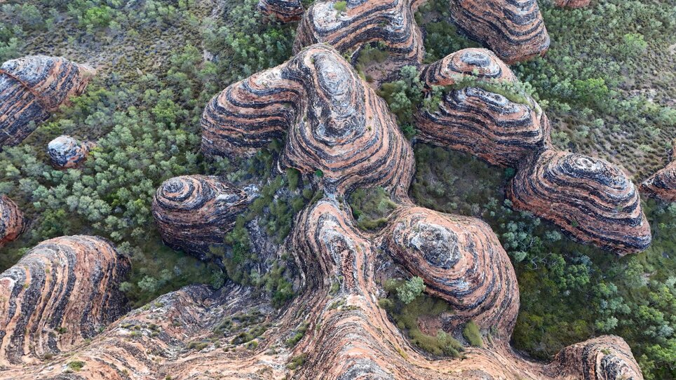 Luftaufnahme von wellenförmigen Felsen und Grünflächen in Australien. | © Gerhard Huber