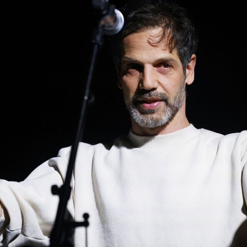 Yousef Sweid - steirischer herbst 2025 | © Ute Langkafel A man passionately speaks into a microphone on a dark stage. | © Ute Langkafel
