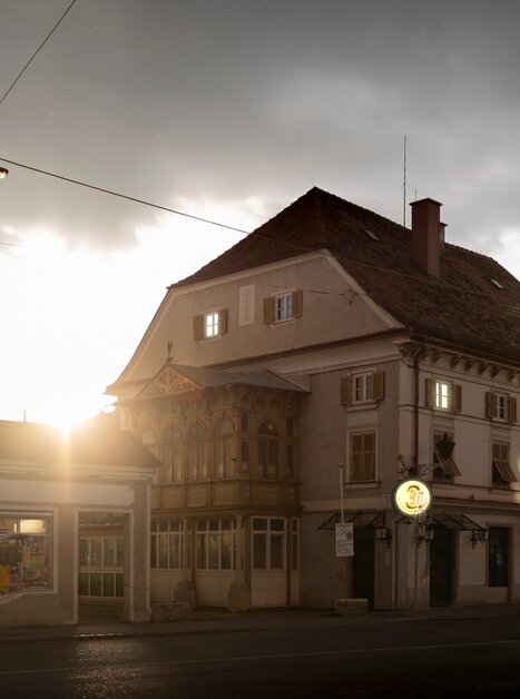 Blick auf ein altes Gebäude mit Fenstern und leuchtendem Schild | © steirischer herbst - Dietmar Reinbacher