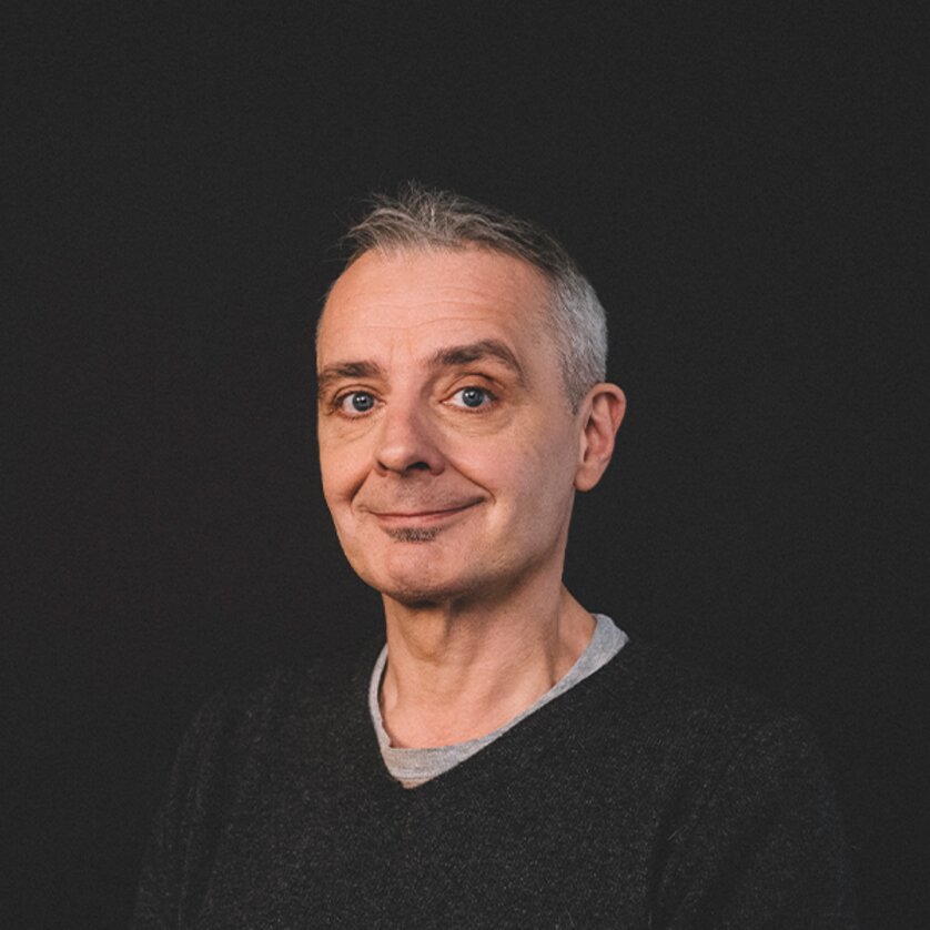 Der Kabarettist Thomas Maurer trägt einen schwarzen Pullover und schaut mit einem Lächeln in die Kamera | © Ingo Pertramer