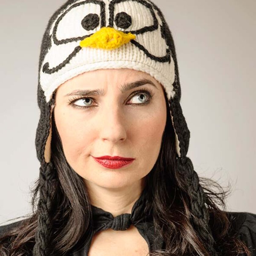 Eine Frau trägt eine gemusterte Mütze mit einem Pinguinmotiv. | © Gary Milano