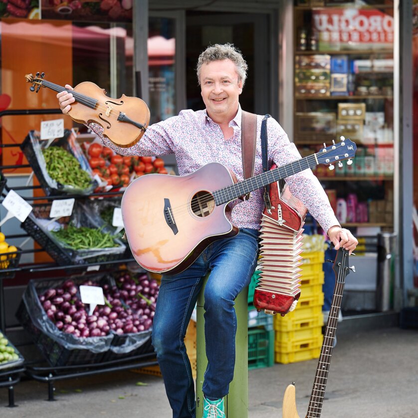 Kabarettist Thomas Strobl mit Instrumenten auf dem Markt | © Sabine Klimt Kabarettist Thomas Strobl mit deinen Instrumenten an einem Marktstand. | © Sabine Klimt