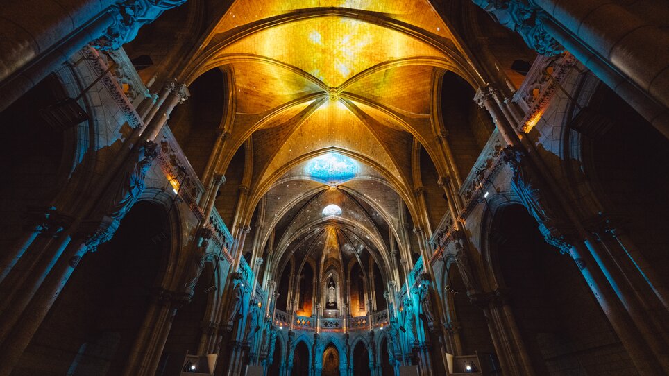 Faszinierende Innenansicht einer beleuchteten gotischen Kathedrale. | © Projektil