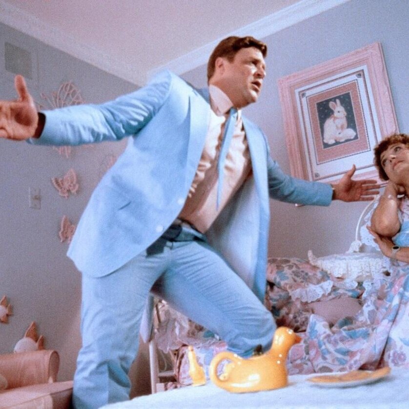 Mann im hellblauen Anzug performt in einem Zimmer mit pastellfarbenen Wänden. | © 1986 Warner Bros. - Jonathan Demme
