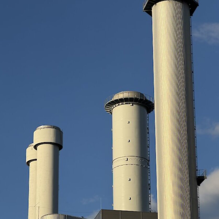 Image shows tall chimneys of an industrial plant under a blue sky. | © Sascha Paar