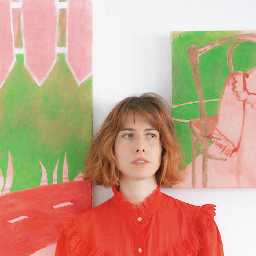 Woman in red blouse stands in front of colorful murals | © Luca Celine Mueller