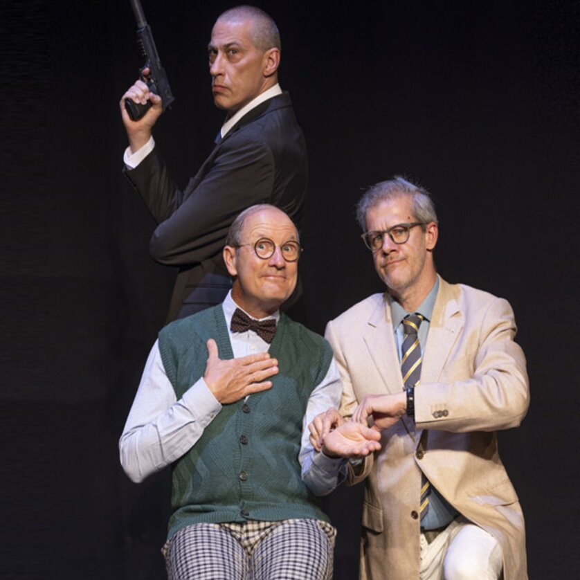 Drei Schauspieler in Kostümen auf der Bühne, einer mit Pistole. | © Komödie Graz