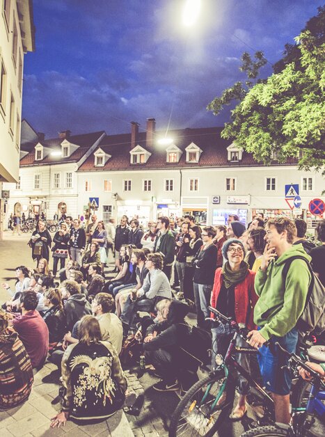 Menschen versammeln sich beim Lendwirbel neugierig vor einem Bildschirm im Freien. | © Lupi Spuma