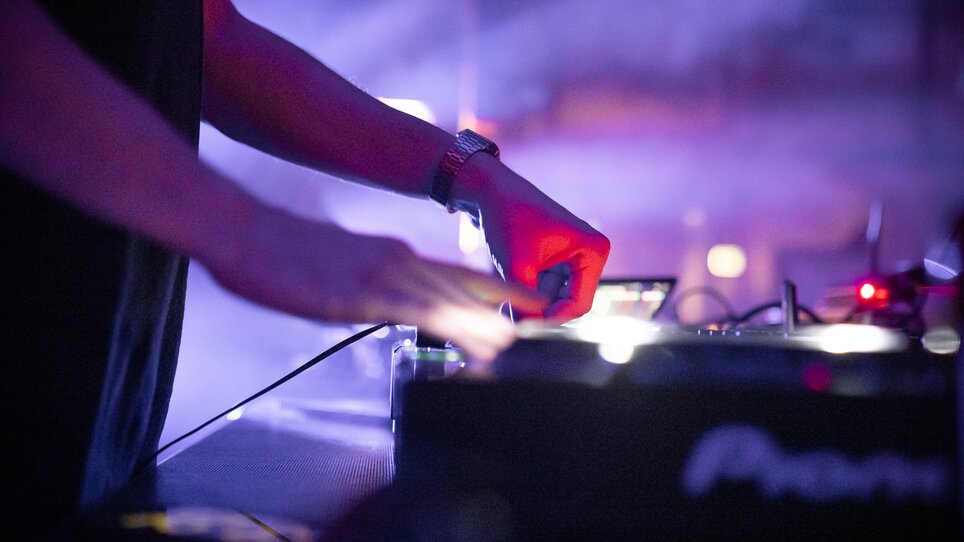 Ein DJ konzentriert sich auf sein Equipment während einer Live-Performance. | © Silent Disco Austria