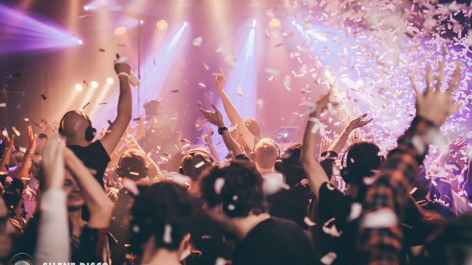 Teilnehmer einer Silent Disco feiern mit Kopfhörern und Konfetti. | © Silent Disco Austria