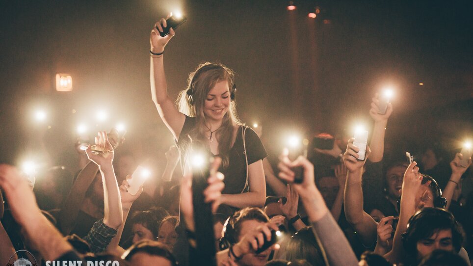 Das Publikum erhebt die Hände mit Lichtern während einer Silent Disco. | © Silent Disco Austria
