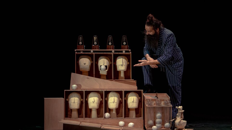 Ein Künstler interagiert mit Masken und weißen Bällen auf einer Bühne. | © Sol Álvarez