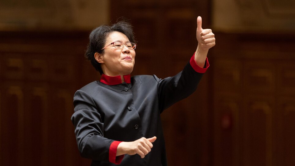 Dirigentin Mei Ann Chen zeigt ihren Daumen hoch und lächelt. | © Nikola Milatovic