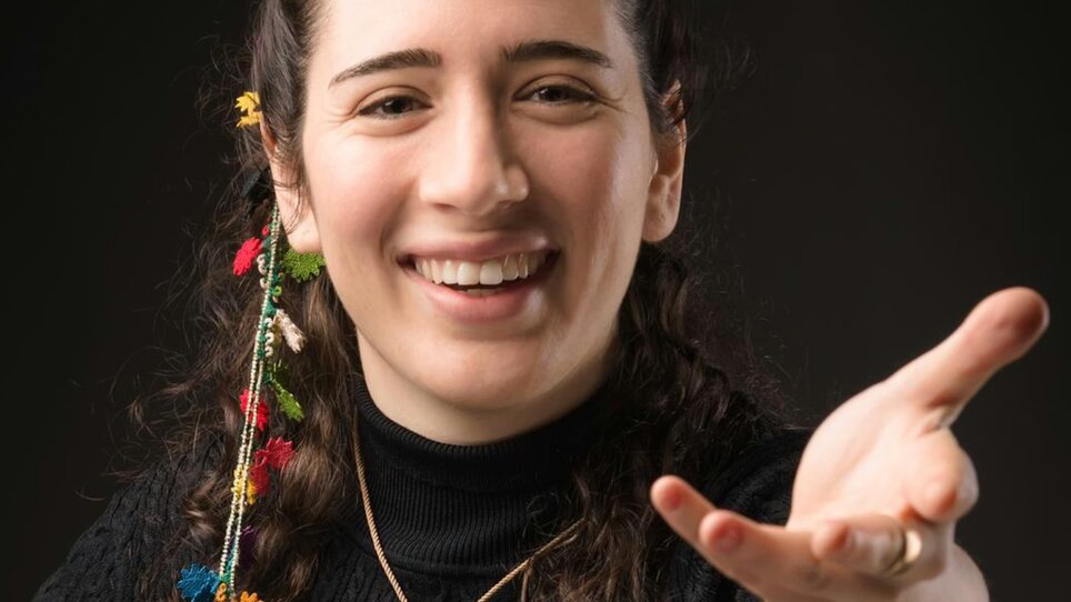 Portrait von Nil Venditti, sie trägt ein schwarzes Oberteil und Blumen im Haar. | © Alessandro Bertani