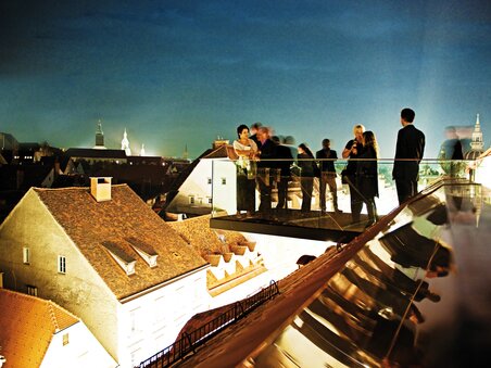 Networking on a modern terrace in Graz at night.