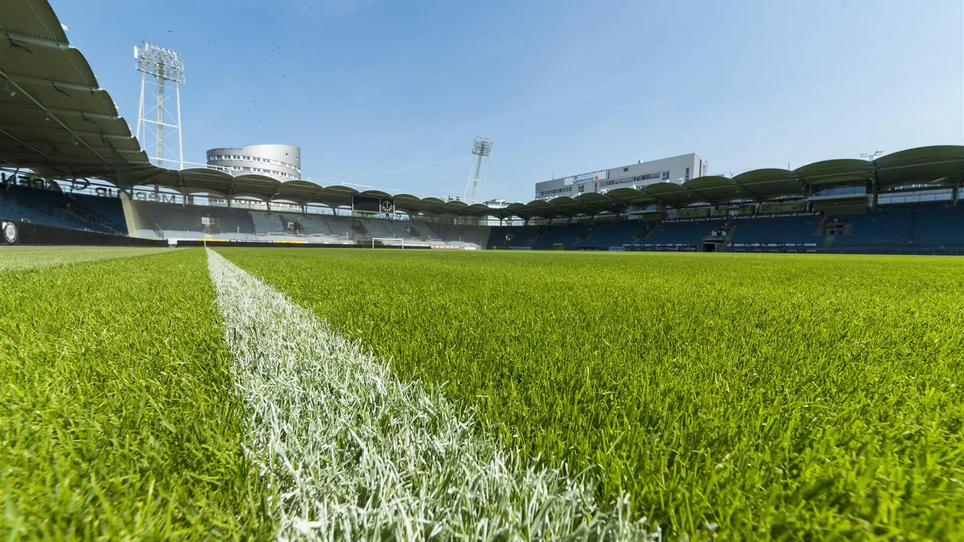 Grüner Rasen und Tribünenansicht in der MERKUR Arena Graz.