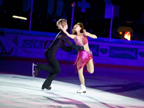 A couple in glamorous outfits skating on stage. | © MCG - Martin Wiesner