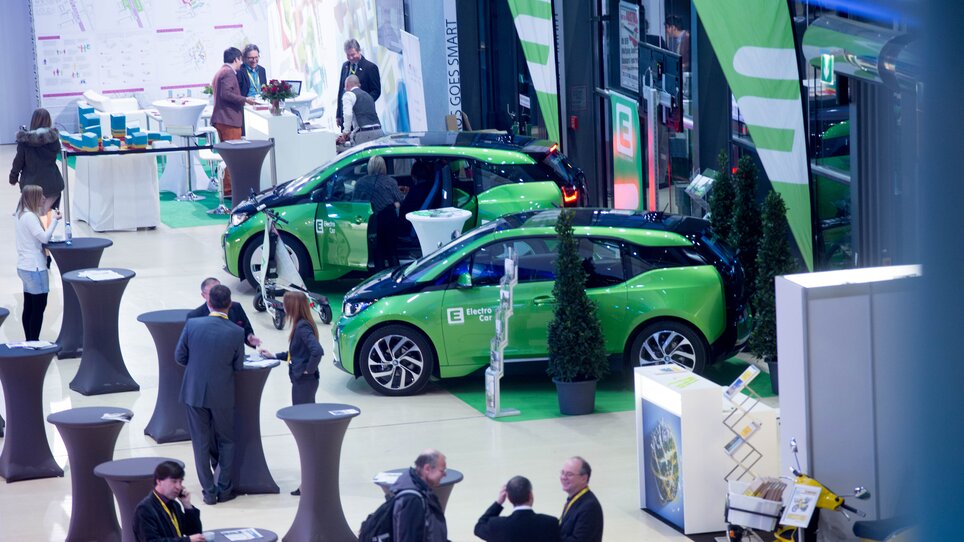 Business meeting with electric cars at a convention. | © MCG - Martin Wiesner