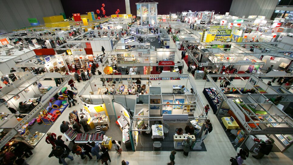 Overview of a business trade fair with booths and attendees. | © MCG - Martin Wiesner