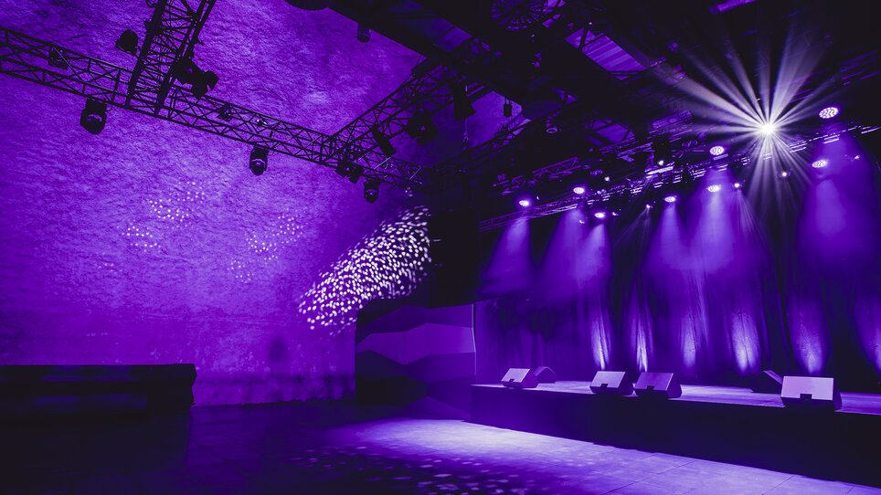Flexible Eventfläche mit technischer Infrastruktur und lila Licht | © Lupi Spuma