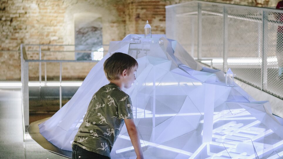 Ein Junge betrachtet eine interaktive, leuchtende Installation in einem modernen Raum. | © Sebastian Reiser