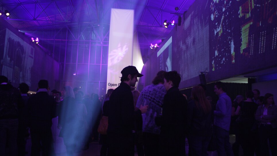 Menschen bei einem Networking-Event in modernem, beleuchtetem Raum. | © Helmut List Halle