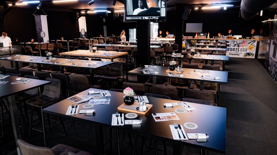 Interior of the SportsBar - Das Eggenberg, set for a conference with tables and decoration. | © Sebastian Atzler