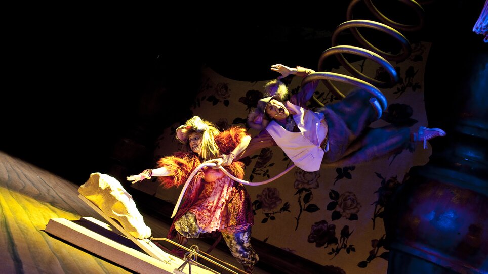 Ein kreatives Theaterstück wird aufgeführt. Die Schauspieler sind lebhaft, in bunter Kostümierung und agieren in einer dynamischen Szene. Next Liberty bietet eine inspirierende Atmosphäre für kreative Veranstaltungen. | © Lupi Spuma