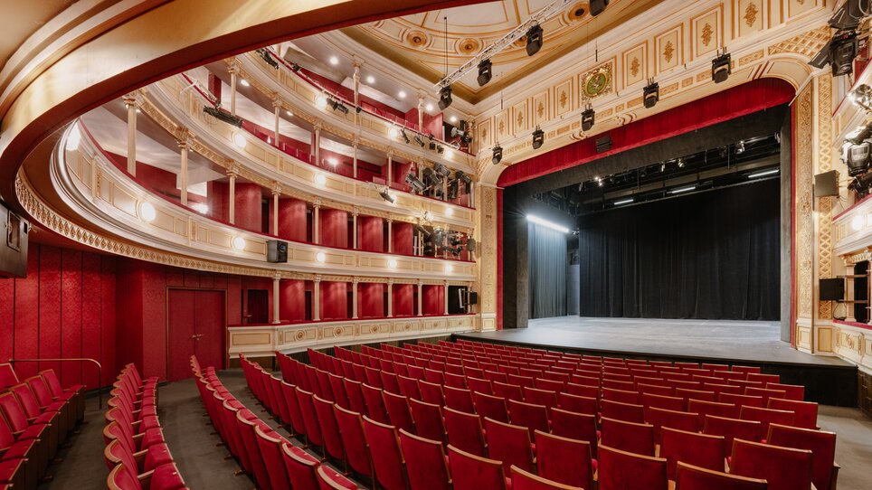 View of the elegant theater interior featuring red velvet seating. | © Lex Karelly