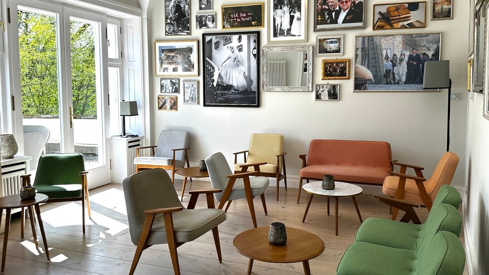 Ein einladender Raum mit Sitzgelegenheiten und Fotowänden. | © Schloss Vasoldsberg