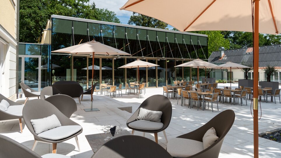 Einladende Terrasse mit modernen Möbeln und Sonnenschirmen. | © Kurt Elmleitner Fotografie