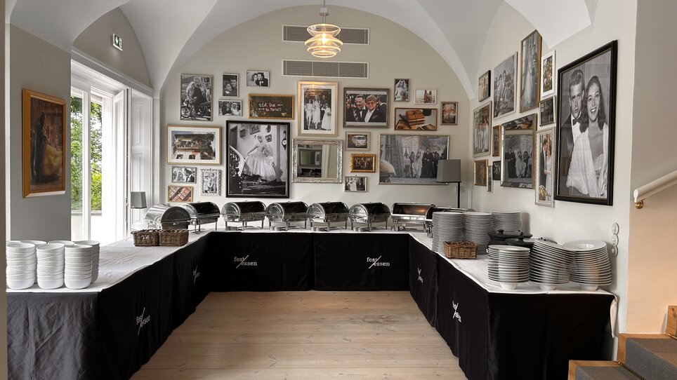 Eleganter Raum im Schloss Vasoldsberg mit gedecktem Buffet und Bilderwand. | © Schloss Vasoldsberg
