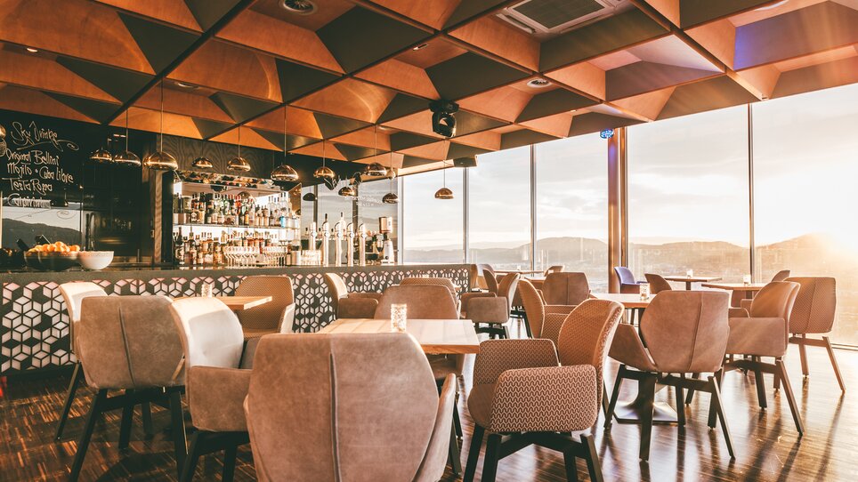 Moderne Architektur mit Holzdecke, beleuchtetem Barbereich und gemütlichen Sitzbereichen. Ideal für Tagungen und Business-Events. | © Werner Krug