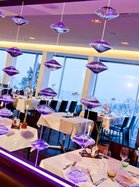 Modern interior with table arrangement, large windows, and lighting in the Schlossberg Restaurant. Ideal for conferences and business meetings. | © Schlossberg Restaurant