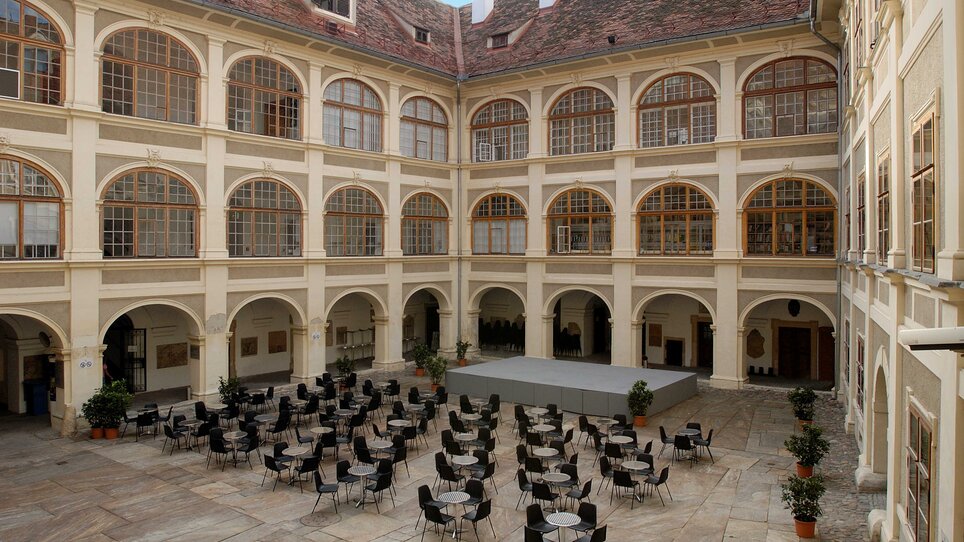 A large courtyard in Graz with tables and chairs for events. | © UMJ