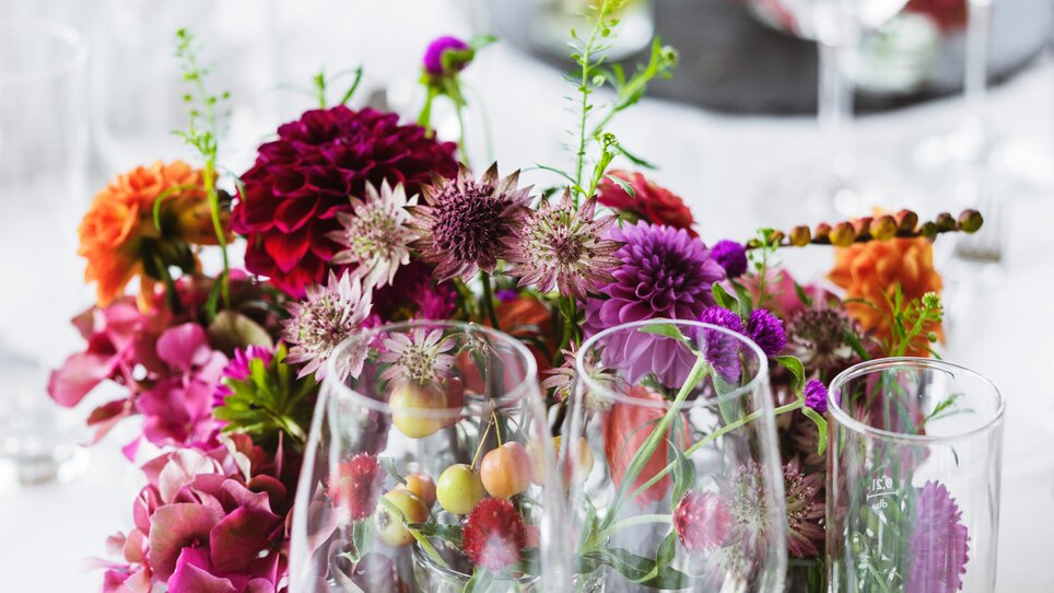 Tischdekoration mit bunten Blumen und Gläsern im Hotel Daniel Graz | © Florian Weitzer Hotels & Restaurants