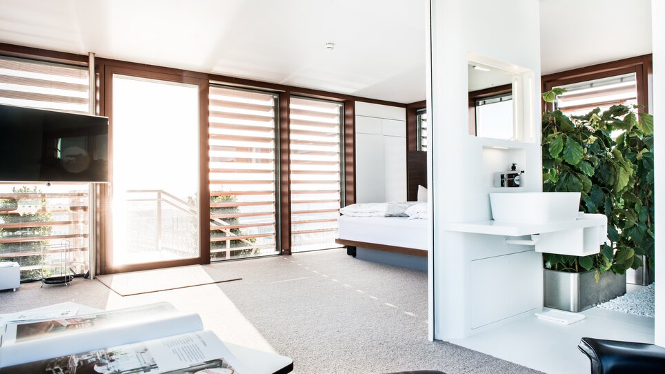 Helle und elegante Suite im Hotel Daniel Graz mit Blick auf das Bett und die Pflanzen. | © Florian Weitzer Hotels & Restaurants