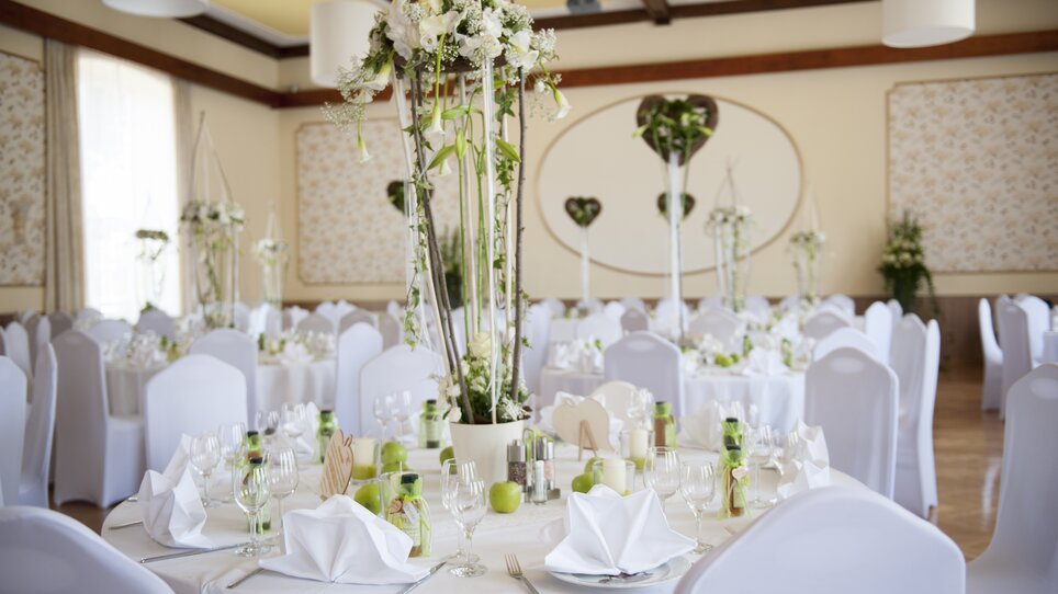 Festively decorated tables with flower arrangements and apples at Hotel-Gasthof Pendl. | © Thomas Wasle