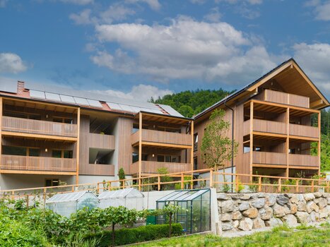 Helle, moderne Wohngebäude mit Holzverkleidung und angrenzendem Garten bei der Genusspension Herti. | © Grossauer