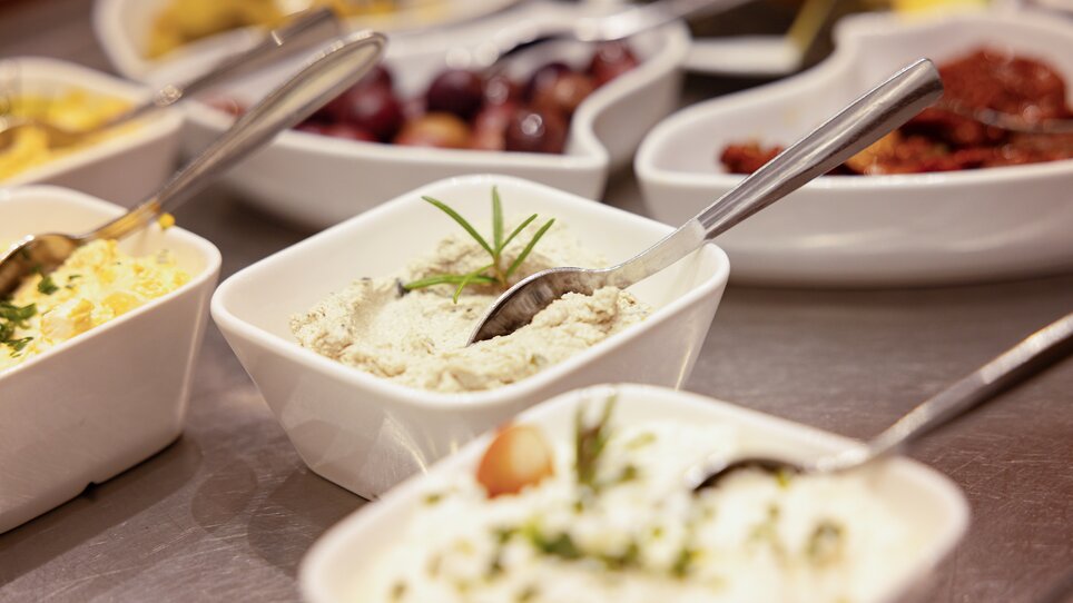 A selection of dips and sides in white bowls, garnished with herbs at the Hotel Gollner. | © Hotel Gollner