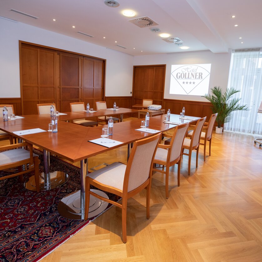 Conference room with table, chairs, and presentation setup at Hotel Gollner. | © Hotel Gollner