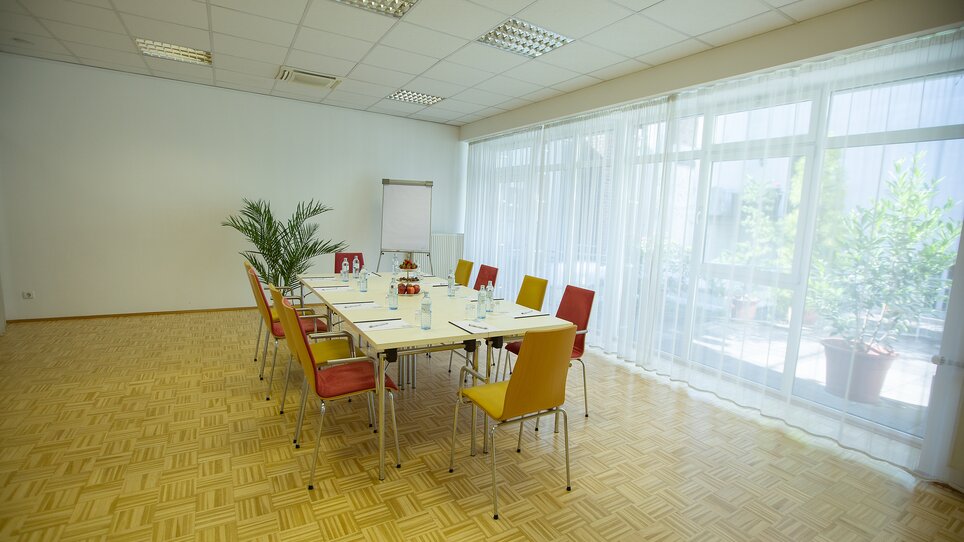 A bright, modern conference room with table and chairs at Hotel Gollner. | © Hotel Gollner