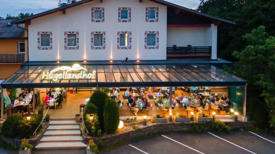 Das Restaurant Hügellandhof mit vielen Gästen im Freien am Abend. | © Hügellandhof