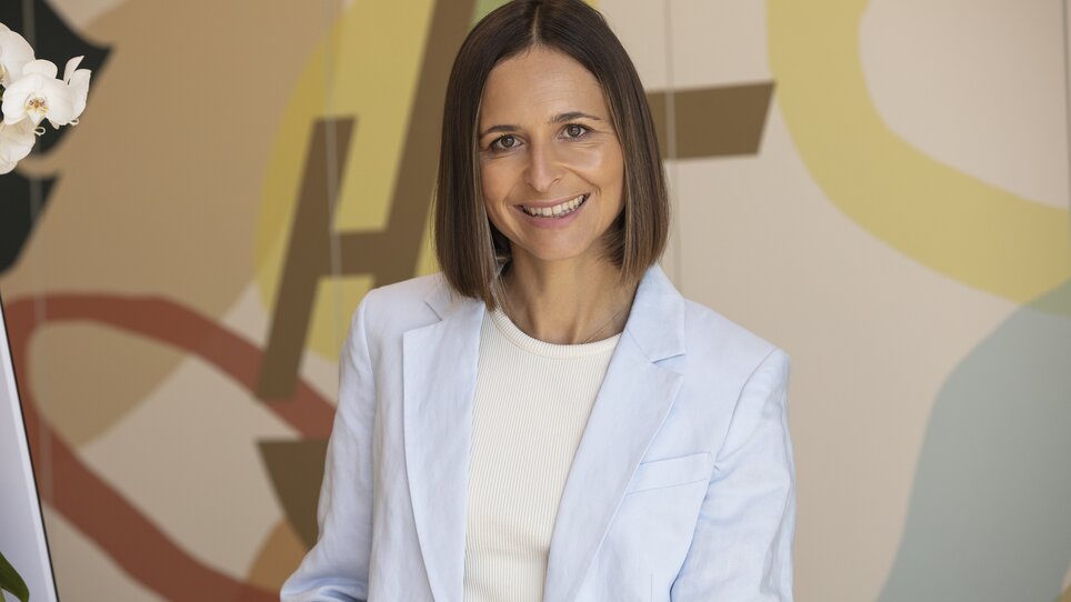 A businesswoman smiles at Hi5-Hotel Seiersberg. Bright setting. | © Hi5-Hotel Seiersberg